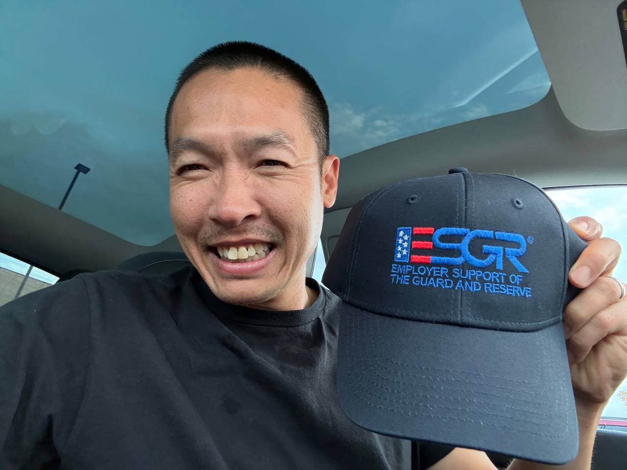 Di Tran holding an ESGR Employer Support of the Guard and Reserve hat after the Boss Lift event.